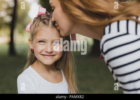 Aux cheveux blonds aimante Mère embrassant son joli preschool girl Banque D'Images