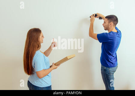 Vue de profil d'un beau jeune homme à faire des trous dans un mur Banque D'Images