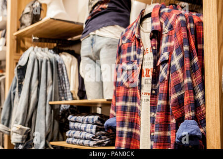 Shorts, chemises, T-shirts et une veste sur l'étagère du magasin. Des vêtements à la mode sur les étagères du magasin. Vitrine, vente, shopping. Luxe et fashionab Banque D'Images