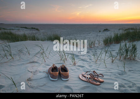 Deux paires de chaussures au coucher du soleil sur une plage de la mer du Nord dans la région de Saint- Peter-Ording, Allemagne Banque D'Images