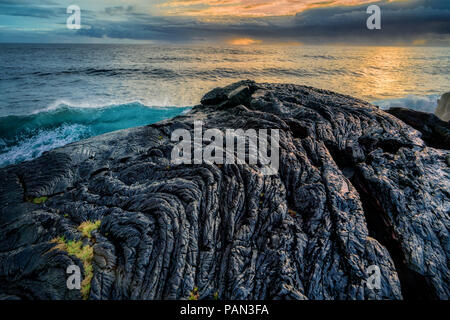 Pahoehoe lava flow, le lever du soleil et l'océan. La Puna Coast, New York. Banque D'Images