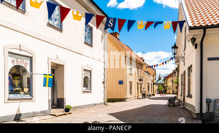 Soderkoping, Suède - le 29 juin 2018 : journée d'été ordinaire dans le village. Le Cobblestone rue pavée de Storgatan avec son look vintage. Les gens walki Banque D'Images
