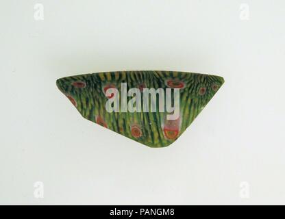 Fragment de mosaïque de verre de bol. Culture : Roman. Dimensions : 1 3/4 9/16 × × 1/8 in. (1,4 × 4,5 × 0,3 cm) diamètre estimé : 7 1/16 in. (18 cm). Date : fin du 1er siècle avant J.-C.-début 1er siècle de notre ère. Bleu turquoise translucide qui apparaissent en vert, jaune opaque, blanc et rouge. Outsplayed avec RIM, à bords latéraux verticaux ;, peut-être d'un grand bol profond. Modèle mosaïque composite formé de sections d'une seule canne dans un sol bleu turquoise parsemé de nombreuses tiges jaunes et parfois des stries rouges, entourant une tige centrale de couleur incertaine (bleu ou violet) décrites par bagues en jaune, rouge, Banque D'Images