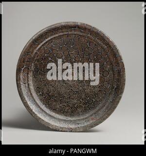 Mosaïque de verre plat. Culture : Roman. Dimensions : H. 13/16 in. (2 cm) de diamètre 6 à 5/16. (16 cm). Date : fin du 1er siècle avant J.-C.-début 1er siècle de notre ère. Violet translucide, incolore, opaque, blanc, opaque, rouge et jaune opaque ; anneau de base en couleur incertaine. Rim horizontal avec bord arrondi ; carinated, côté peu profond, avec deux courbes convexes ; fond plat ; faible appliqué anneau de base, constituée d'un même circuit. Modèle mosaïque composite formé à partir de deux sections polygonales cannes similaires : une dans une masse mauve bordées de blanc, chacune avec un cercle rouge entouré d'un groupe de tiges jaunes, l'Othe Banque D'Images