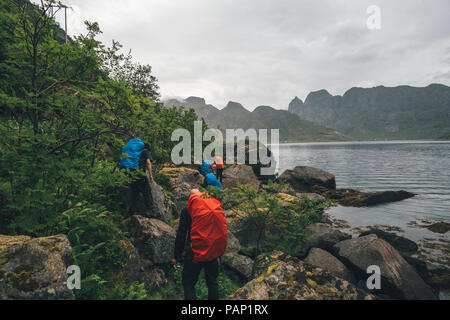 La Norvège, les îles Lofoten, Moskenesoy, groupe de randonneurs marchant le long Kjerkefjord Banque D'Images