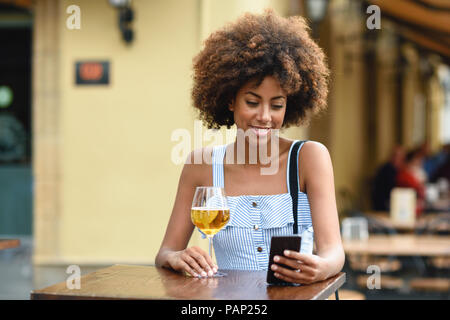 Portrait of young woman with smartphone boire de la bière en plein air Banque D'Images