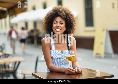 Portrait of happy young woman drinking beer outdoors Banque D'Images