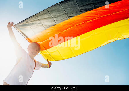 Garçon, enthousiaste pour le championnat du monde de soccer, en agitant le drapeau allemand Banque D'Images