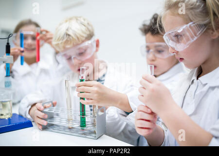 Les élèves en classe de sciences, l'expérimentation avec des liquides dans des tubes à essai Banque D'Images