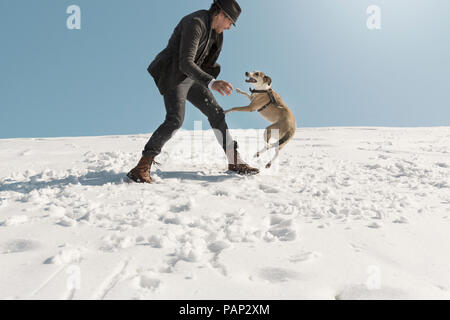 Man Playing with dog en hiver, dans la neige Banque D'Images
