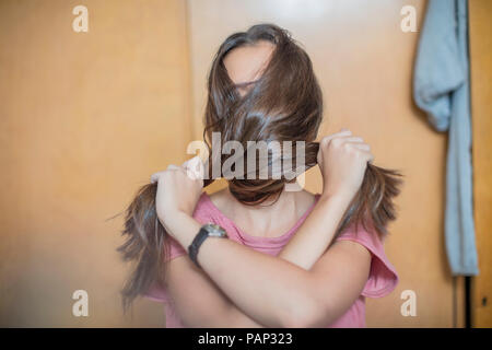 Teenage girl couvrant son visage avec ses cheveux Banque D'Images