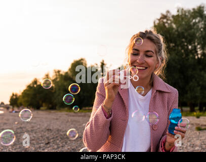 Femme blonde rire et bulles de savon Banque D'Images