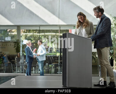 Smiling collègues debout sur la scène du lutrin Banque D'Images