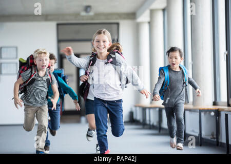 Les élèves enthousiastes se précipiter school corridor Banque D'Images