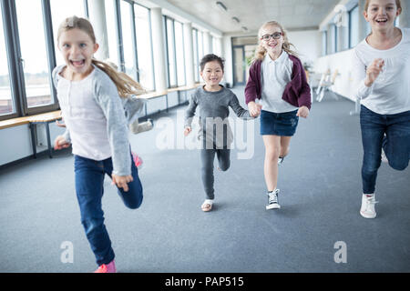 Ecolières excité se précipiter school corridor Banque D'Images