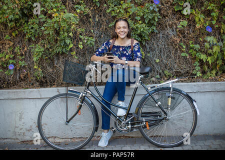 Portrait of smiling teenage girl with cell phone et location Banque D'Images