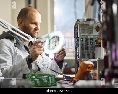 Technicien travaillant en laboratoire électronique Banque D'Images