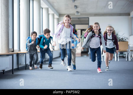 Les élèves enthousiastes se précipiter school corridor Banque D'Images