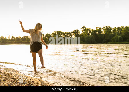 Jeune femme marchant pieds nus sur Riverside Banque D'Images