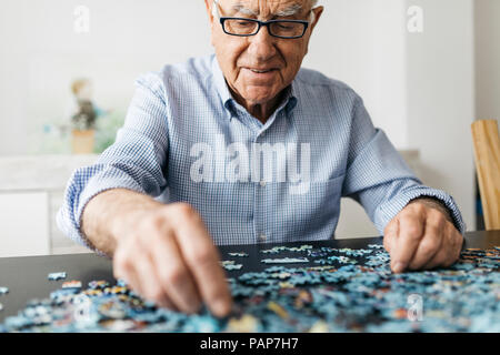 Faire un puzzle denteux Senior man Banque D'Images