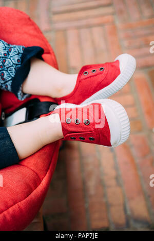 Avec pieds bébé chaussures rouges dans la poussette Banque D'Images