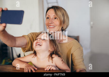 Portrait de Mère et fille en tenant avec smartphone selfies Banque D'Images