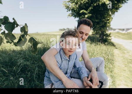 Portrait of young man embracing boy à un champ Banque D'Images