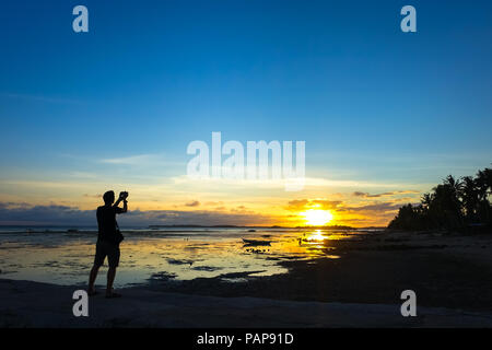 Photographe de voyage l'homme à prendre des photos d'une belle île bleue de soleil sur une plage rocheuse - Aklan - Philippines, Boracay Banque D'Images