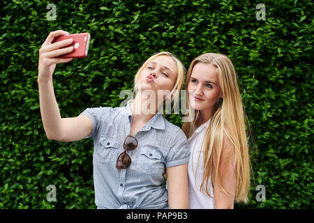 Deux jeunes femmes posant pour une couverture à un selfies Banque D'Images