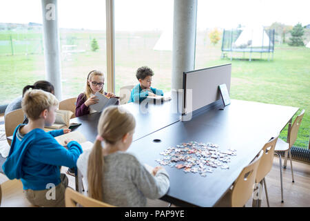 Les élèves à lire des livres sur la table à l'école de la salle de pause Banque D'Images