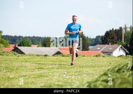 Man running on meadow Banque D'Images