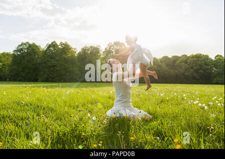 Mère et fille jouer sur prairie en été Banque D'Images