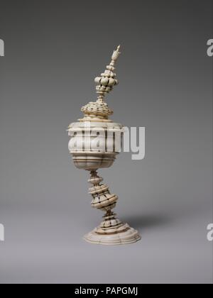 Coupe du comité permanent. Culture : l'allemand, Nuremberg. Dimensions : hors tout : 14 × 5 × 4 1/4 in. (35,6 × 12,7 × 10,8 cm). Bouilloire : Peut-être de l'atelier par Lorenz Zick (1594-1666) ; éventuellement par atelier de Stephen Zick (mort en 1715). Date : le 17e siècle. La technique de formage d'objets sur un tour, ou en tournant, a atteint un haut degré de complexité dans le époques Renaissance et Baroque, lorsque le français, italien, et de l'Europe centrale a produit des ateliers-papier évidé fine des formes de blocs d'ivoire unique. Des ecclésiastiques et nobles embrassé le tournant d'un passe-temps. Parmi les dirigeants qui ont rassemblé des chefs-d'œuvre de tournant pour leur Banque D'Images