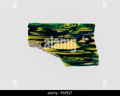 Fragment de mosaïque de verre de type encastré. Culture : Roman. Dimensions : hors tout : 1 x 1 11/16 in. (2,5 x 4,3 cm). Date : fin du 1er siècle avant J.-C.-début 1er siècle de notre ère. Bleu turquoise profond translucide, partiellement mélangé avec apparaissant jaune vert, violet apparaissant rouge brique, jaune et opaque. Télévision, plaque triangulaire, avec une partie de l'une à bords inégaux ; face inférieure avec des tirets de l'outillage. Mosaïque de marbre dans la masse vert jaune avec des stries, des tourbillons et des bielles, avec deux minutes de zones dans le rouge. Ébréché sur un coin ; face supérieure polie ; de piqûres dans des bulles de surface ; et ternir l'altération crémeuse sur le dessous Banque D'Images