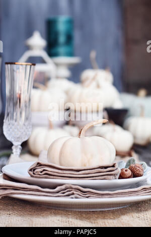 Placer sur une table pays ferme rustique avec mini white pumpkins et verres de cristal pour Thanksgiving Day ou un dîner d'Halloween. Banque D'Images