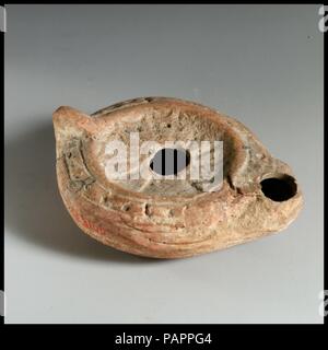 Lampe en terre cuite. Culture : Roman. Dimensions : hors tout : 1 1/4 x 3 7/16 in. (3,2 x 8,7 cm). Date : 5e-6e siècle. Poignée de porte-fusée. Sur disque, rosette angulaire ; sur l'épaule, bande d'échelle à motif. Musée : Metropolitan Museum of Art, New York, USA. Banque D'Images