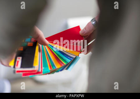 Close-up of man holding color swatches in office Banque D'Images