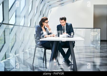 Young vérification des documents at desk in modern office Banque D'Images