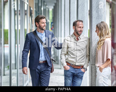 Business people talking outside office building Banque D'Images