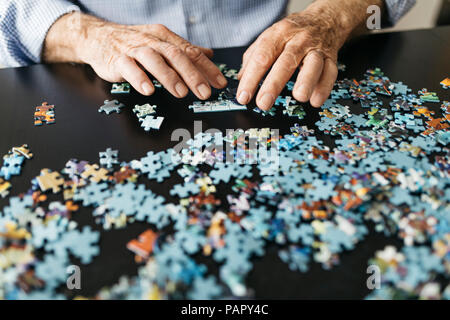 Faire un puzzle denteux Senior man Banque D'Images