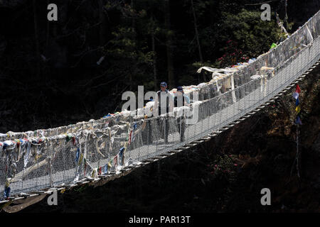 Solo Khumbu, Népal, Everest, Sagamartha Parc National, deux personnes traversant suspension bridge Banque D'Images
