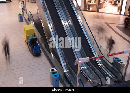 Une longue exposition photo de deux escaliers mécaniques au terminal de l'aéroport Rome lounge avec des membres du public zipping passé allant à et de leurs vols Banque D'Images