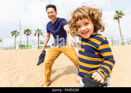 Espagne, Barcelone, père et fils jouent sur la plage Banque D'Images