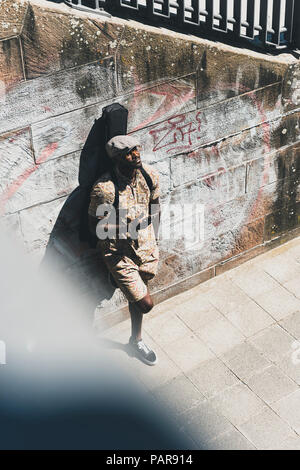 Jeune homme de la ville, transportant des cas, l'utilisation de guitare smartphone Blackberry Banque D'Images