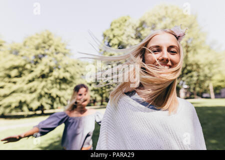Portrait de deux jeunes femmes heureux d'exécution dans un parc Banque D'Images
