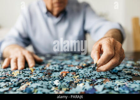 Faire un puzzle denteux Senior man Banque D'Images