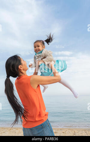 Heureuse mère jouant avec sa fille sur la plage Banque D'Images