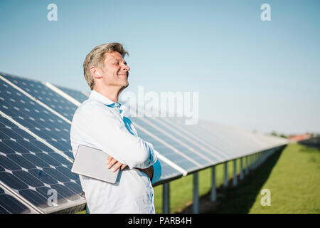 Avec l'aide d'écouteurs sans fil d'affaires tablet à solar park Banque D'Images