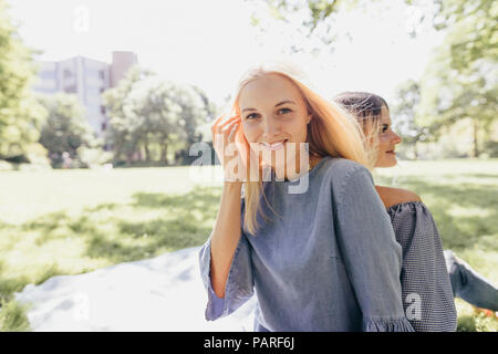 Portrait de deux jeunes femmes souriant dans un parc de détente Banque D'Images