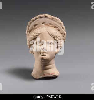 Tête de femme en terre cuite. Culture : le grec. Dimensions : H. 2 5/8 in. (6,7 cm). Date : 4ème-3ème siècle avant J.-C.. Le port d'un phendone. Musée : Metropolitan Museum of Art, New York, USA. Banque D'Images